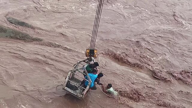 Rescue team evacuating a family from a swollen river during flooding.
