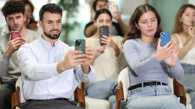 Female student takes pictures during a presentation at a lecture. Students sit in the classroom and scan the QR code to see all the training materials on the site.