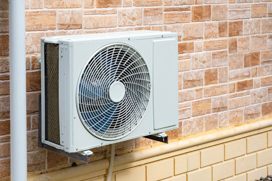 An inverter air conditioner mounted on the wall of a country house