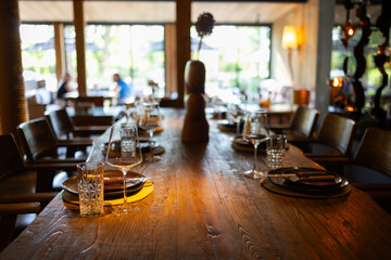 Elegant restaurant interior with cozy seating and warm lighting. A table served for celebration or wine party at a bar or restaurant. © Mykola