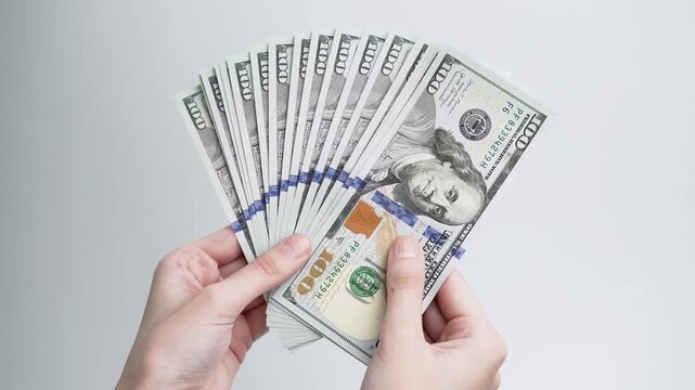 Female hands counting stack of dollar banknotes isolated on white background. Cash payment, savings, financial planning, investment and money management concept.	
