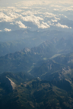 Swiss Alps mountain landscape with winding river and rugged valley seen from airplane, Switzerland