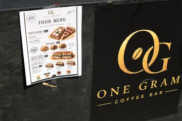 Fototapeta premium paper food menu and sign outside One Gram Coffee Bar located at 466 Danforth Av, Greektown, Toronto