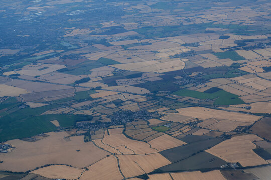 Aerial view of agricultural landscape and patchwork farmland seen from airplane, travel and tourism