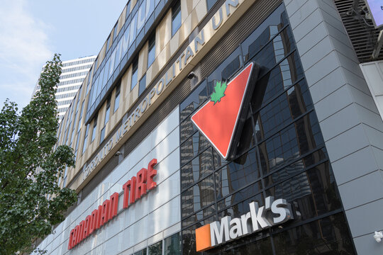 perspective view of building facade with signs including that of Canadian Tire, a department store chain, located here at 65 Dundas St W, CF Toronto Eaton Centre