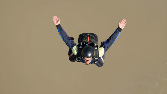 Skydiver in freefall wearing parachute harness and jumpsuit