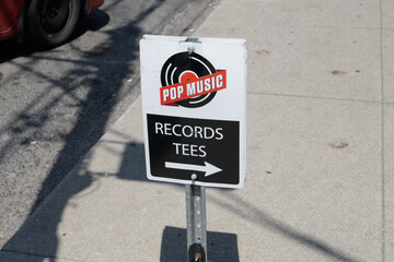 Fototapeta premium small metal sidewalk shop sign of Pop Music, a record store, located at 345 Broadview Av, Toronto