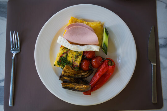 Healthy hotel breakfast with omelette, vegetables and ham, travel holiday leisure food concept