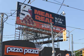 Fototapeta premium rooftop billboard and signage outside Pizza Pizza, a pizza restaurant chain, located here at 85 Danforth Av, Toronto (southwest corner of Broadview Av)