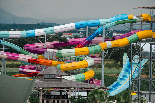 Side, Turkey, July 25, 2026: Colourful water park slides with tropical landscaping, travel holiday leisure background
