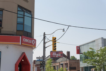 Fototapeta premium looking south on Pape from Danforth Av with signs of Circle K convenience store chain, Scotiabank, and a rooftop billboard, Toronto