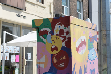 Fototapeta premium painted traffic control box by Adrianne Chan outside (a defocused) Sammi 森記, a cafe, located at 862 Danforth Av, Toronto