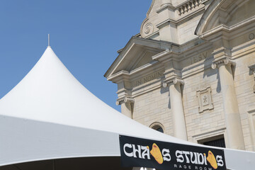 Fototapeta premium special events tent with banner for Chaos Studios pitched in front of the Church of the Holy Name, during Taste of the Danforth, 2026, Toronto