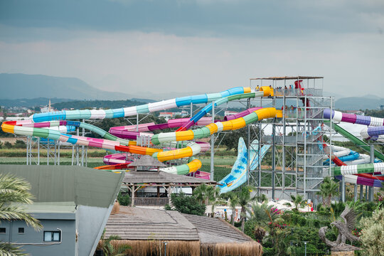 Side, Turkey, July 25, 2026: Colourful water park slides with tropical landscaping, travel holiday leisure background