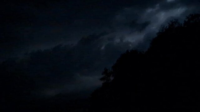 dark stormy night sky with lightning over highway road - dramatic weather dark clouds, thunderstorm atmosphere, electric blue lighting, ominous sky, flash
