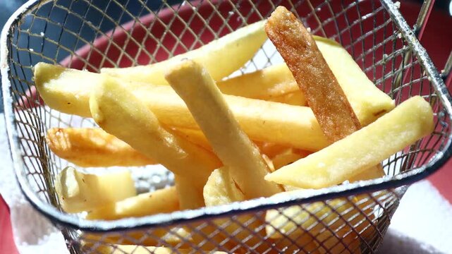 A basket filled with French fries sitting on a table, perfect for snacking or serving at a gathering