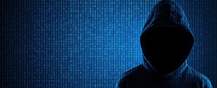 Hacker in hoodie standing before a digital cyber screen with binary code data