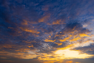 Fototapeta premium Stunning Sunset Sky with Colorful Clouds and Golden Horizon,A breathtaking view of a vibrant sunset sky filled with dramatic golden, orange, and pink clouds scattered across a serene blue atmosphere,