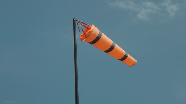 A colorful kite soaring through the air, with a strong wind blowing
