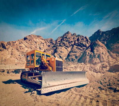 Vintage retro effect filtered hipster style travel view of Bulldozer doing road construction in Himalayas. Ladakh, Jammu alongside Kashmir, India