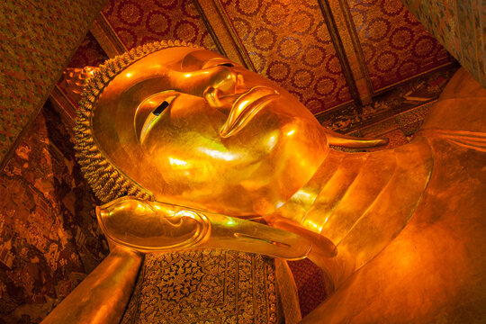 Reclining Buddha gold statue face in Wat Pho, Bangkok, Thailand