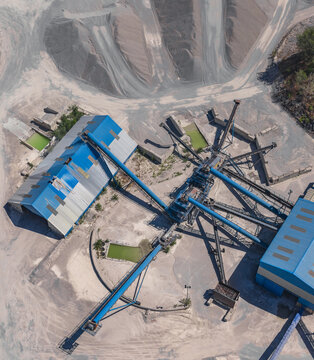 Aerial view of an industrial aggregate processing plant with conveyor belts for transporting and sorting crushed stone into material grades in Valence, Auvergne-Rhone-Alpes, France.