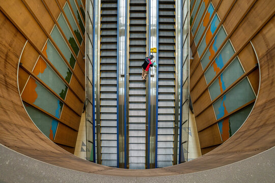 Aerial view of Tokyo Teleport Station featuring a person riding the escalator between curved wooden walls in Koto City, Tokyo, Japan.