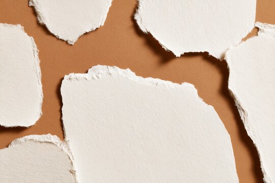 Torn white paper fragments on rustic kraft surface&acirc;&euro;&rdquo;handmade stationery background