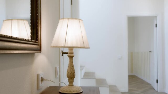 Bright hallway with decorative table lamp and doorways in country house