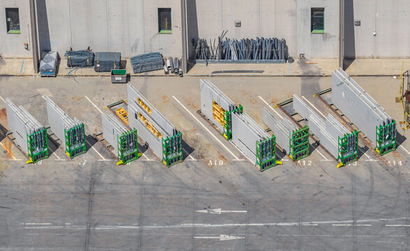 Aerial view of large precast concrete wall panels stored vertically on transport racks outside an industrial manufacturing facility in Valence, Auvergne-Rhone-Alpes, France.