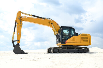 Excavator working in a sandy quarry, digging and moving sand. Industrial construction scene showing heavy machinery operating at a sand extraction site. © senssnow