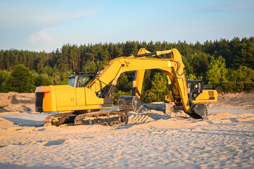 Excavator working in a sandy quarry, digging and moving sand. Industrial construction scene showing heavy machinery operating at a sand extraction site. © senssnow
