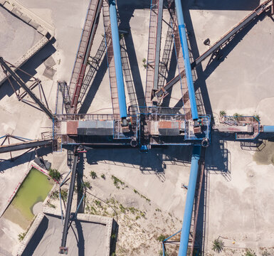 Aerial view of an extensive conveyor belt system transporting and distributing crushed stone at an industrial aggregate processing facility in Valence, Auvergne-Rhone-Alpes, France.