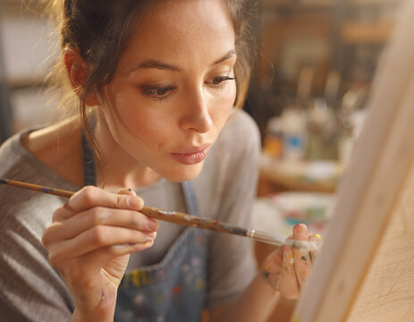 Artista concentrado pintando un lienzo en su taller