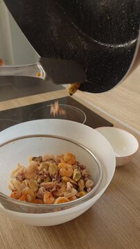 Cooked Seafood Drains in a Metal Colander on a Kitchen Counter, With Shrimp Squid and Mussels Visible During Food Preparation Slow motion Vertical video. Vertical video.