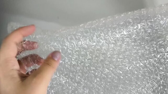 Bubble wrap hold in hands close up, protective packaging material for fragile items, shipping and delivery concept.