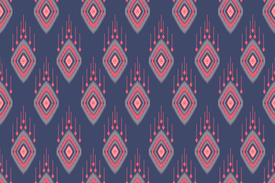 Seamless ikat pattern featuring traditional geometric diamond motifs with hanging fringe elements and soft jagged edges. Set against a deep navy blue background with vibrant coral red, light grey.