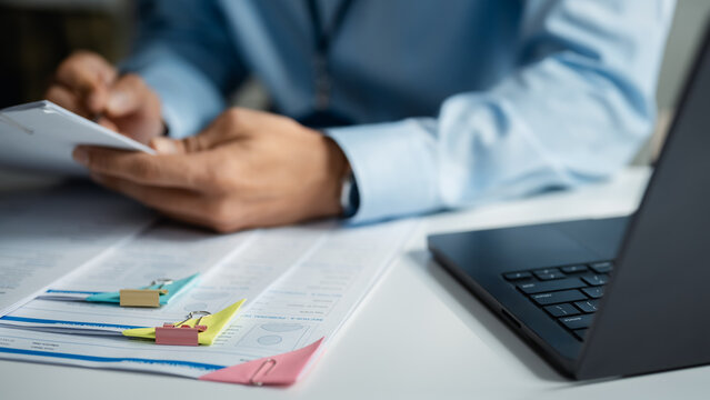 interview resume employment with office hiring; hands reviewing professional paperwork beside a laptop. interview guides buyer choices, resume frames the scene, and employment adds useful meaning.