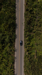 Fototapeta premium Aerial video of a rural road near a mountain with morning mist in Thailand. 