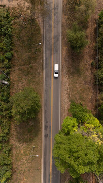 Aerial video of a rural road near a mountain with morning mist in Thailand.	