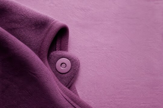 Purple bodysuit fabric with snap fastener closeup textile texture
