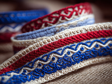 Close-up of Slovak patriotic decorative ribbons, embroidered lace, wooden folk ornaments, soft bokeh background, macro photography, highly detailed, no people