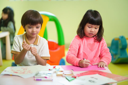 Preschool children enjoy drawing and coloring together in a creative classroom, developing imagination, fine motor skills, and early learning through fun art activities.