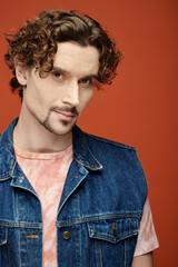 Fototapeta premium Handsome man shows charm and style with emotional expression in a vibrant setting