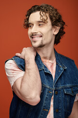 Obraz premium Handsome man expresses emotion in stylish denim attire against a vibrant background