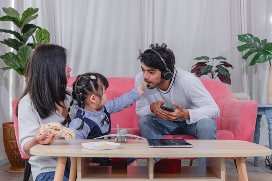 Happy family spending quality time together at home with parents' children enjoying fun and relaxed moment around a table.