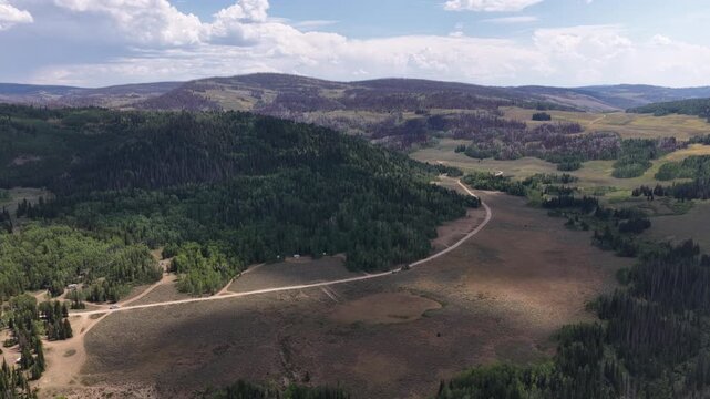 Aerial of Soapstone Basin Road in Wasatch National Forest in Utah in summer with forested landscape and dirt road