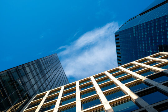 A tilted perspective frames buildings beneath sky in London, while glass reflects the financial district and office architecture folds a facade through sharp angles.