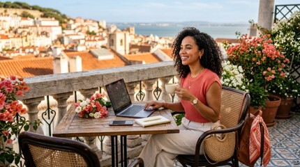 Fototapeta premium Woman working on laptop with coffee on balcony overlooking city and sea