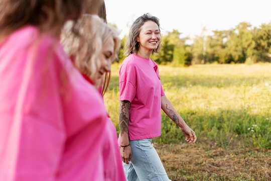 Women wearing pink shirts walking in nature for awareness